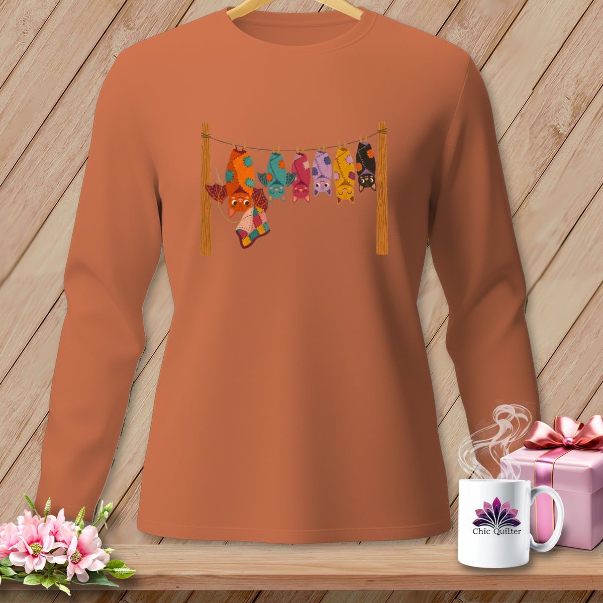 Orange long-sleeve shirt with a graphic of colorful bats hanging on a clothesline.