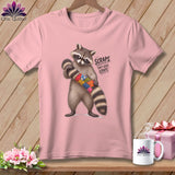 Pink t-shirt with raccoon holding quilt scraps and text 