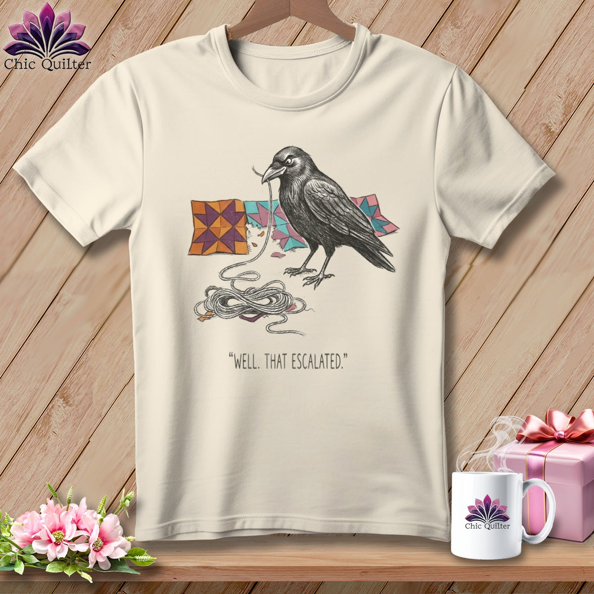 Cream t-shirt with illustration of a crow tangled in yarn and patchwork squares.