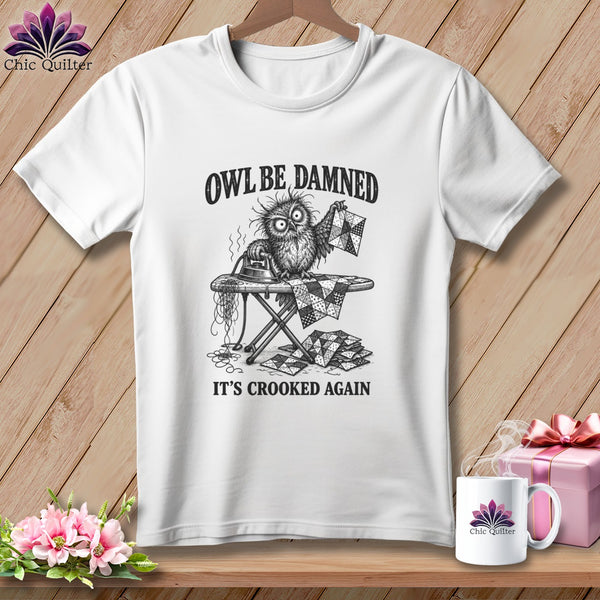 White t-shirt featuring a distressed owl on an ironing board with text: "OWL BE DAMNED IT'S CROOKED AGAIN".