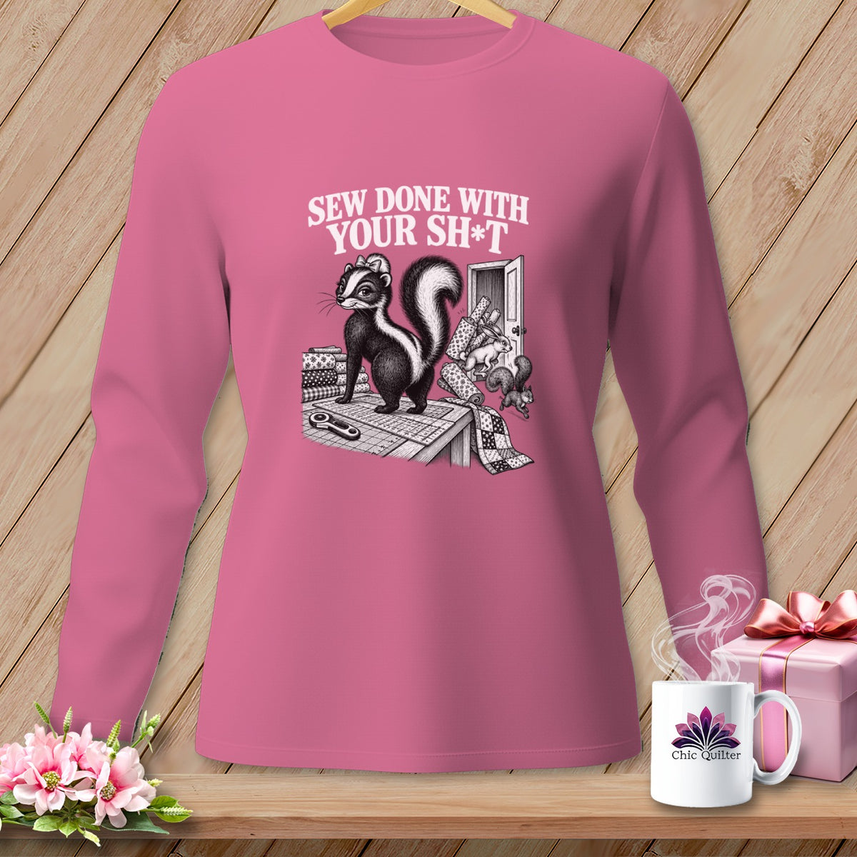 Long sleeve pink shirt with skunk and sewing supplies graphic: "Sew Done With Your Sh*t"