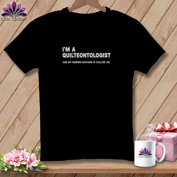 Black t-shirt with "I'M A QUILTEONTOLOGIST AND MY SEWING MACHINE IS CALLING ME" text.
