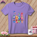 A light purple t-shirt featuring a colorful illustration of four quirky birds sitting on a knitting needle.