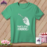 Green t-shirt with white graphic of hand holding scissors cutting fabric and text 