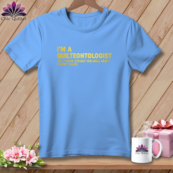 Light blue t-shirt with yellow text: "I'M A QUILTEONTOLOGIST YES, I HAVE STRONG FEELINGS ABOUT FABRIC SALES."