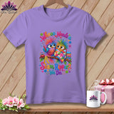 A light purple t-shirt displays a graphic of two colorful cartoon owls on a branch, with text reading Whooo Needs a Seam Ripper? We Do.