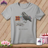 Grey t-shirt with a drawing of a crow holding thread and colorful quilt blocks, with text.