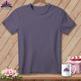 Purple t-shirt with logo, mug, gift box, and flowers on a wooden background.