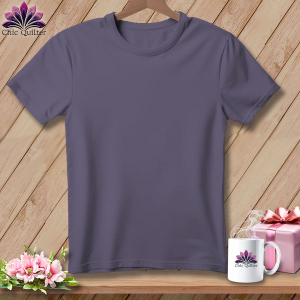 Purple t-shirt with logo, mug, gift box, and flowers on a wooden background.
