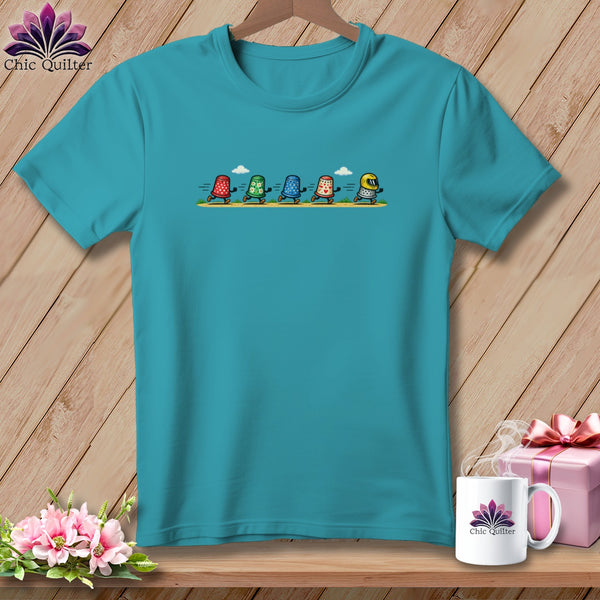 A turquoise crewneck t-shirt featuring a graphic of five running thimbles with different patterns.