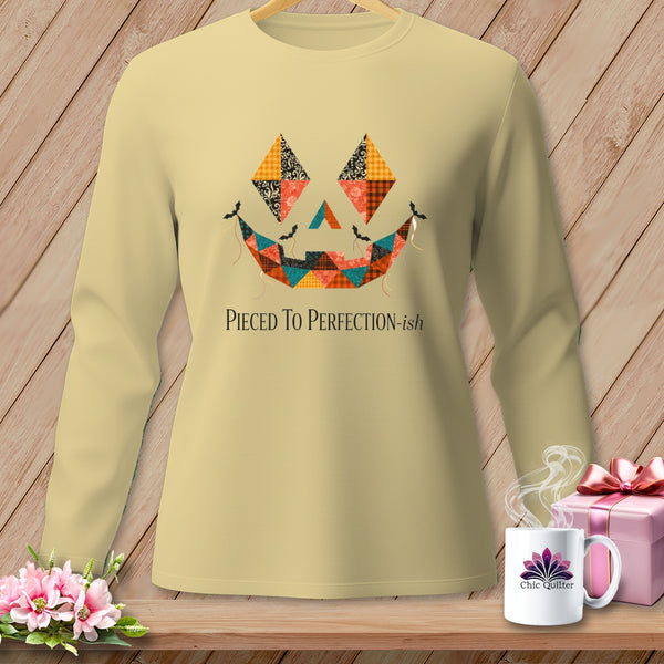 Light yellow long-sleeve shirt with patchwork jack-o'-lantern face and text.