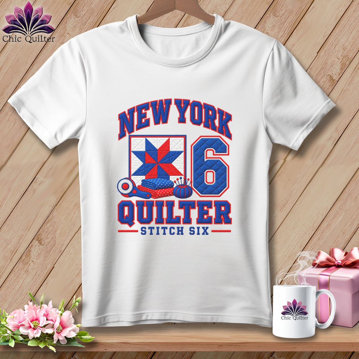 A white crewneck t-shirt featuring a New York Quilter graphic with a red, white, and blue quilt block.