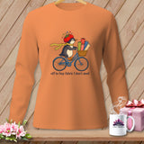 Orange long-sleeve shirt with a penguin on a bicycle, carrying fabric.
