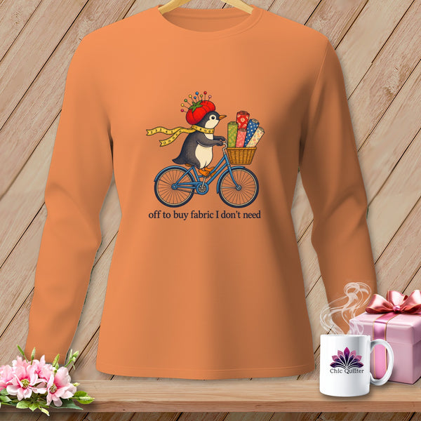 Orange long-sleeve shirt with a penguin on a bicycle, carrying fabric.