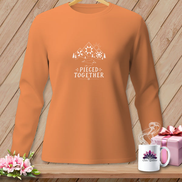 Orange long-sleeve shirt with mountains, trees, and "Pieced Together" text.