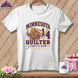 A white t-shirt hanging against a wooden background, featuring purple and yellow text reading Minnesota Quilter First and Sew.