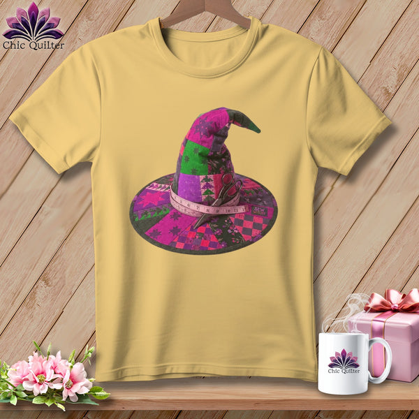 Yellow t-shirt with a patchwork witch hat design, scissors, and measuring tape.