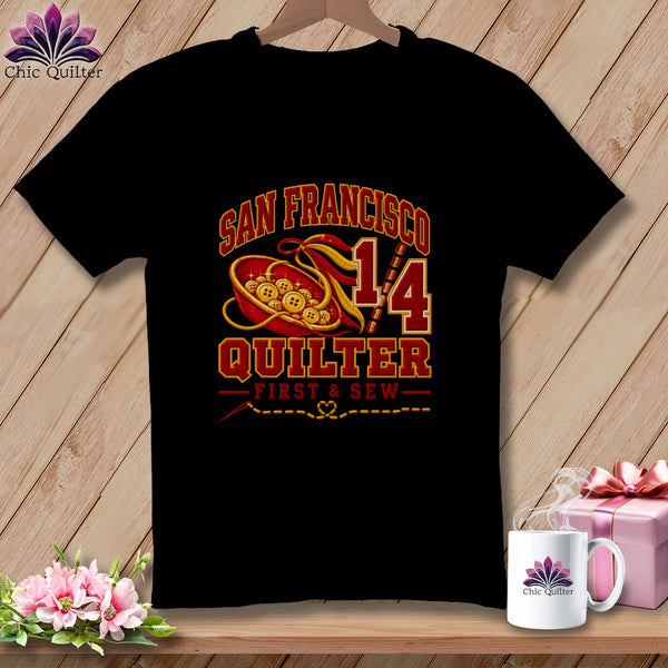 A black t-shirt features a San Francisco Quilter graphic with a bowl of buttons and sewing motifs.