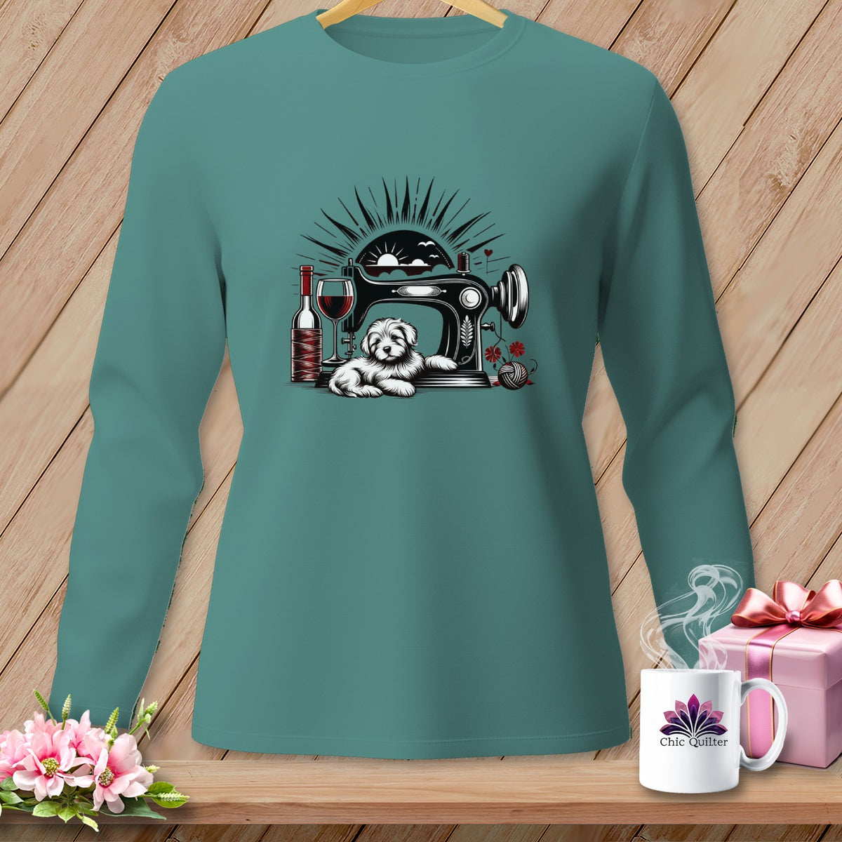 Teal long sleeve shirt with a sewing machine, dog, wine, and yarn graphic.