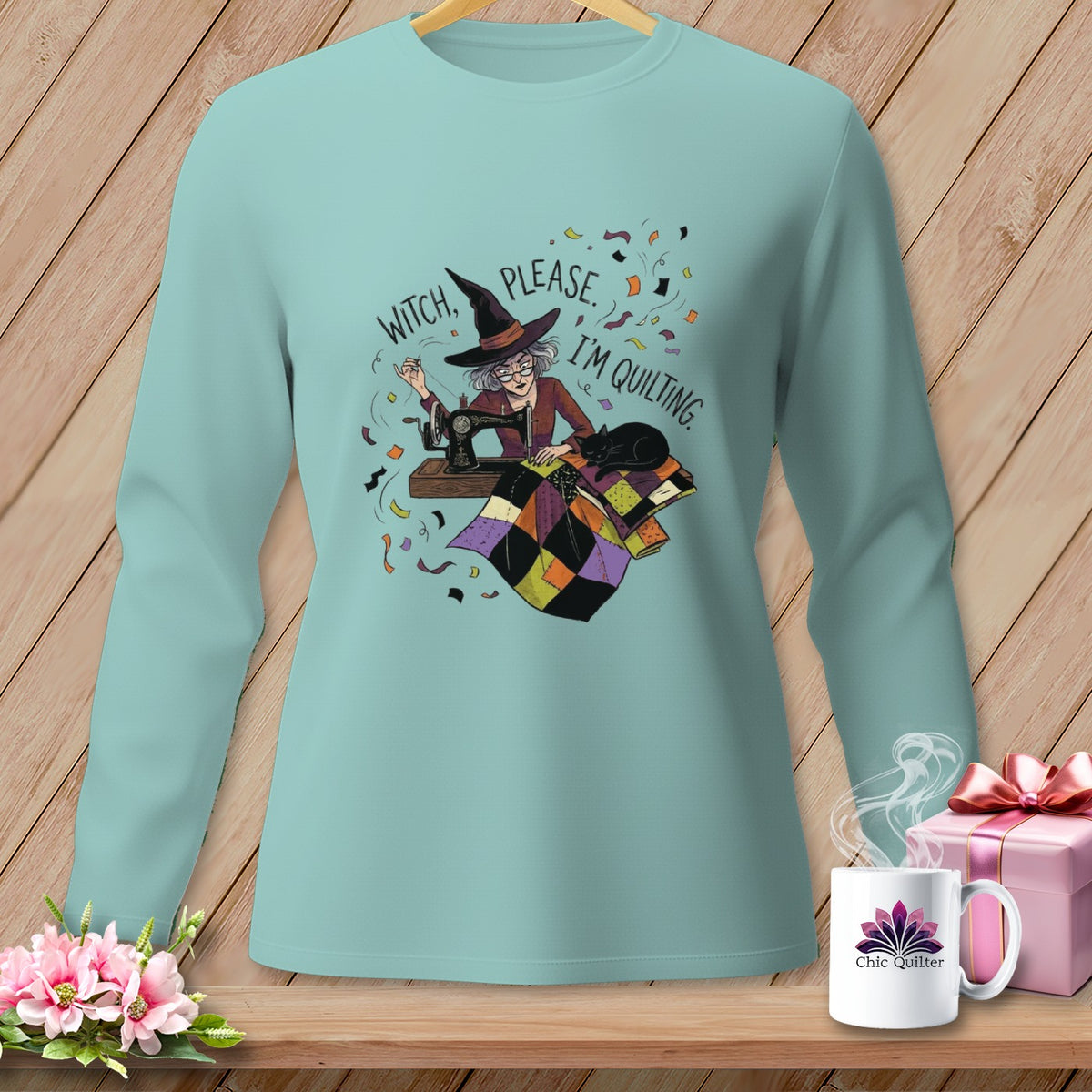 Light blue long-sleeve shirt with a witch quilting and the text "Witch, please. I'm quilting."