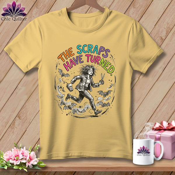 Yellow t-shirt with a distressed graphic of a woman running from bats and scraps of fabric.