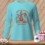 Aqua long-sleeve shirt with red graphic of a woman, scissors, and the text 