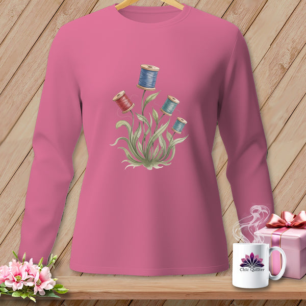 Pink long-sleeve shirt with spool of thread floral graphic and "Chic Quilter" mug.