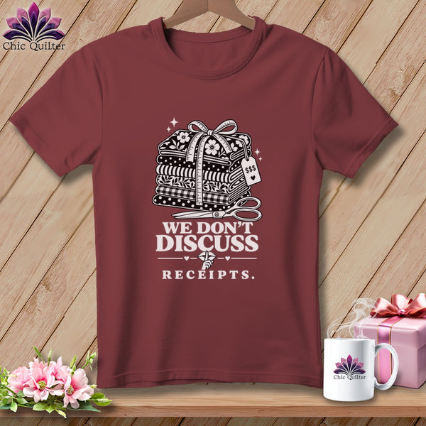 Burgundy t-shirt with stack of fabric, scissors, and text "WE DON'T DISCUSS RECEIPTS."
