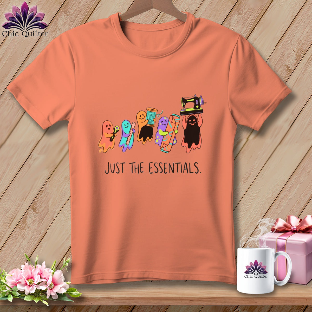 Peach t-shirt with cartoon ghosts holding sewing supplies and the text "JUST THE ESSENTIALS."