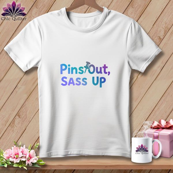 White t-shirt with "Pins Out, SASS UP" text and a thumbtack graphic.