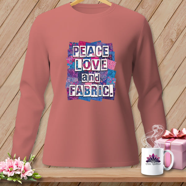 Peach long-sleeve shirt with "Peace Love and Fabric" text design on a patchwork background.