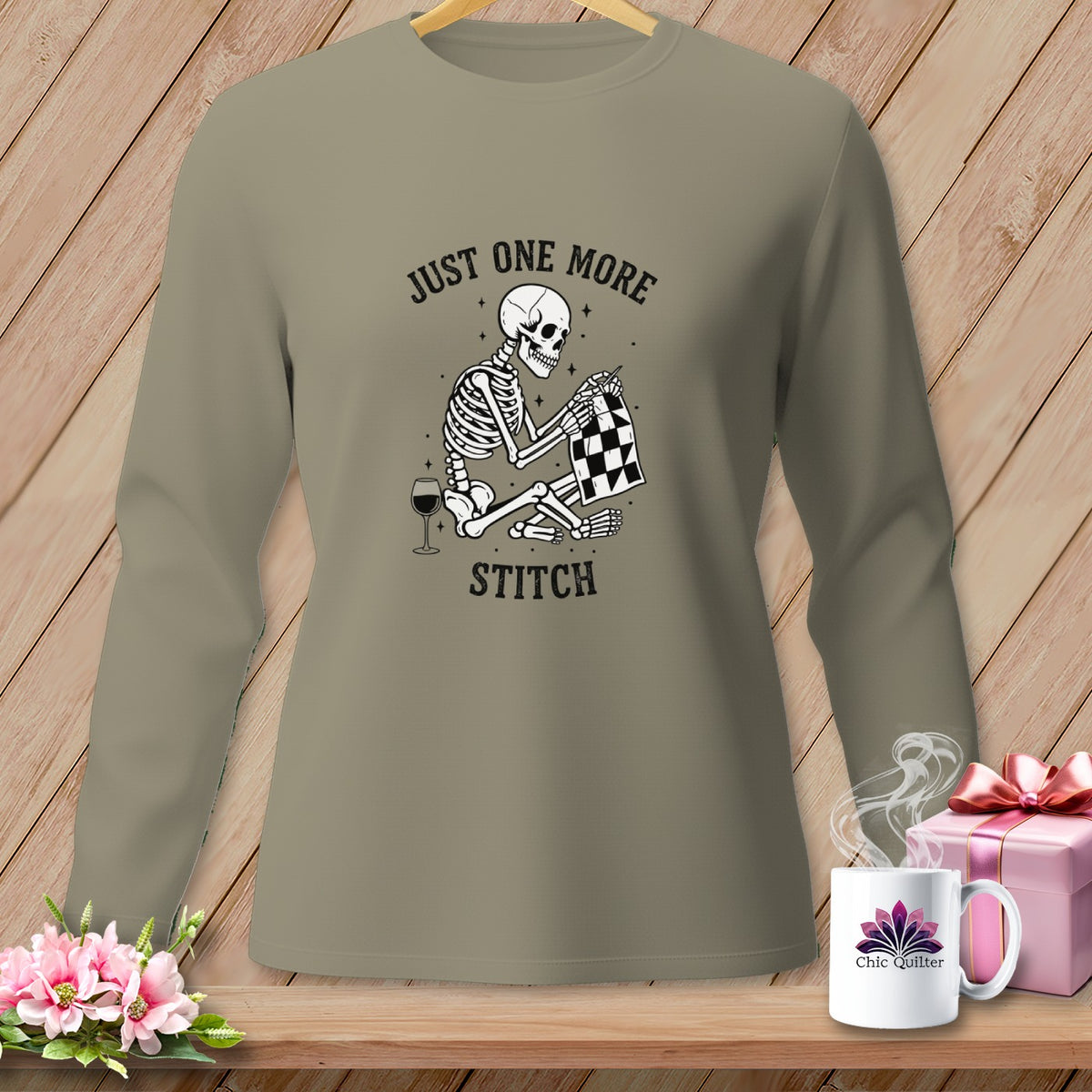 Skeleton sewing with wine glass and text "Just One More Stitch".