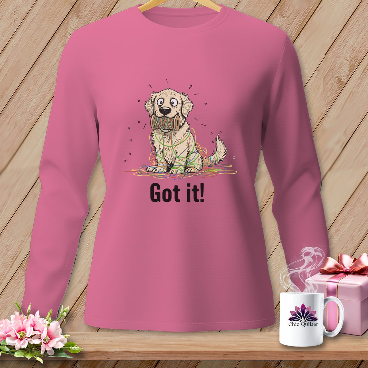 Long-sleeved pink shirt with cartoon dog tangled in colorful yarn, text "Got it!".