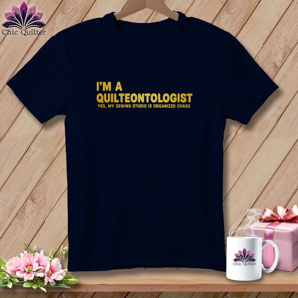 Dark blue t-shirt with yellow text: "I'm a Quilteontologist. Yes, my sewing studio is organized chaos."