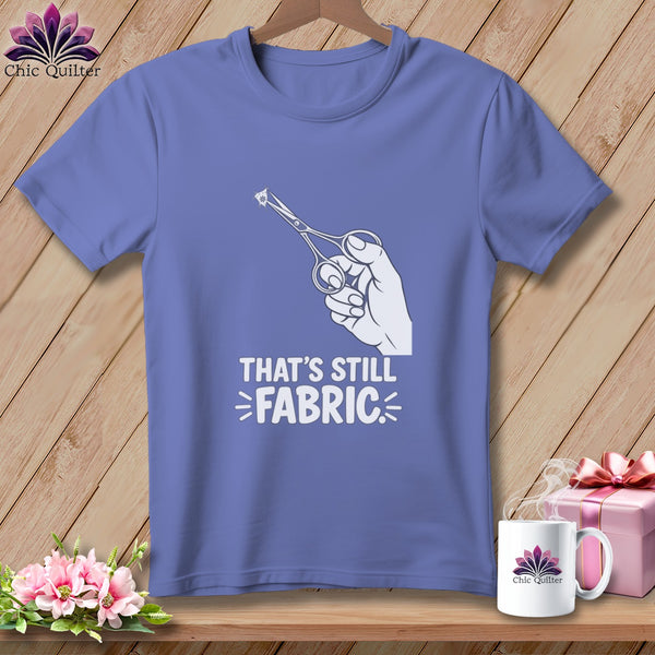 Purple t-shirt with hand holding scissors cutting fabric graphic and text.