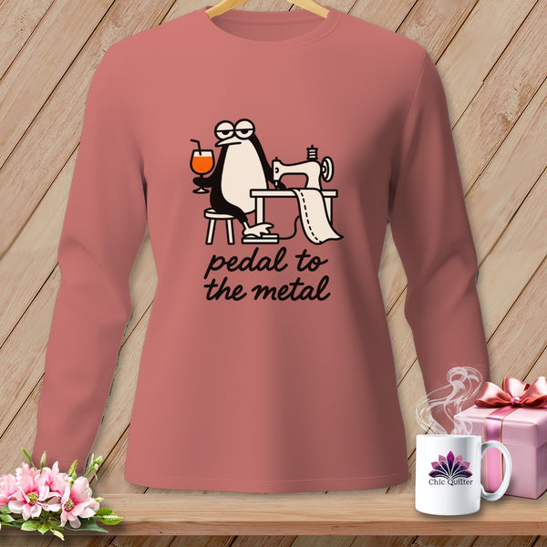 Long-sleeve shirt with a penguin sewing and holding a drink, reads "pedal to the metal".