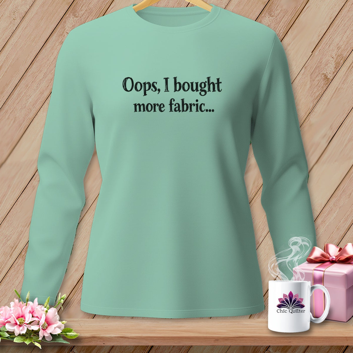 Mint green long-sleeve shirt with black text: "Oops, I bought more fabric..."