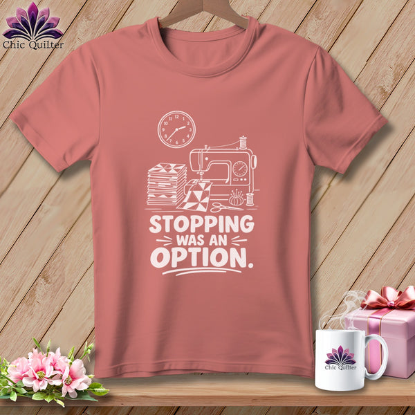 Pink t-shirt with sewing graphic and "Stopping was an option" text.