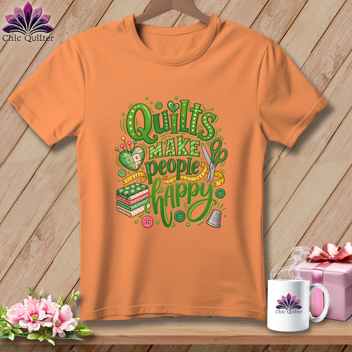 Orange crewneck t-shirt featuring green graphic text that reads Quilts Make People Happy.