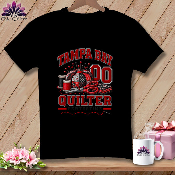 Black t-shirt featuring Tampa Bay Quilter text, a pincushion, thread spools, and scissors design.