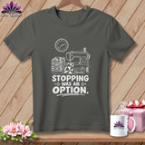 Dark gray t-shirt with a sewing machine, fabric stack, and 