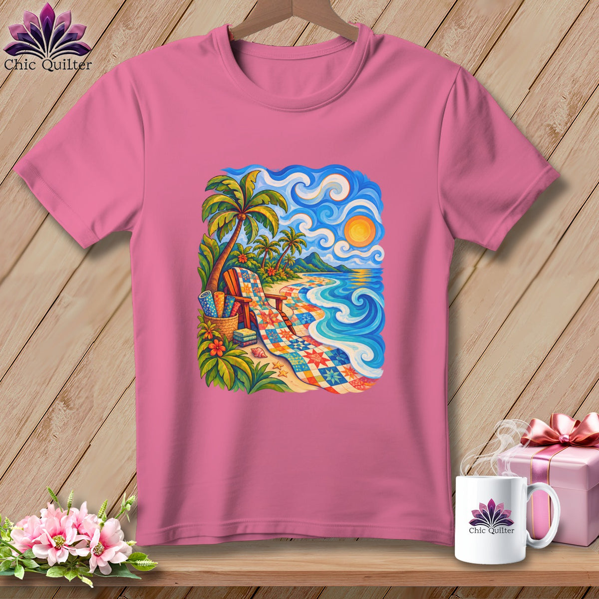 A pink t-shirt hangs on a hanger, featuring a colorful tropical beach landscape illustration centered on the chest.