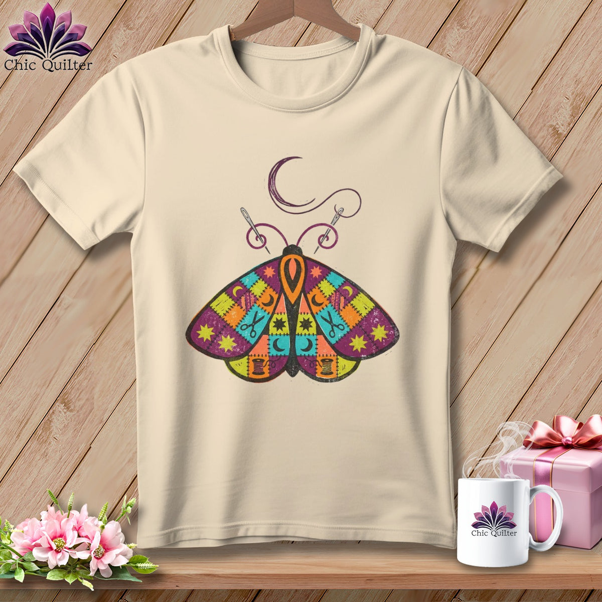 Cream t-shirt with a patchwork moth graphic and sewing accessories.