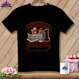 Black t-shirt featuring a Cincinnati Quilter graphic with fabric rolls, a number one, and a measuring tape.