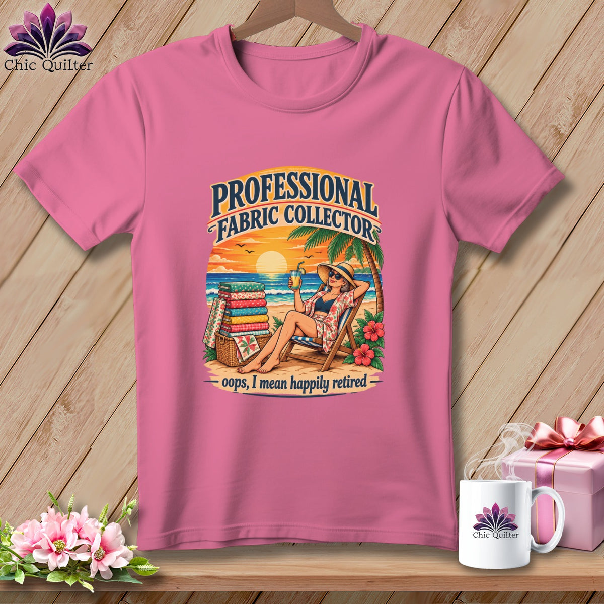 Pink t-shirt with graphic of a woman relaxing on a beach beside a stack of folded fabrics.