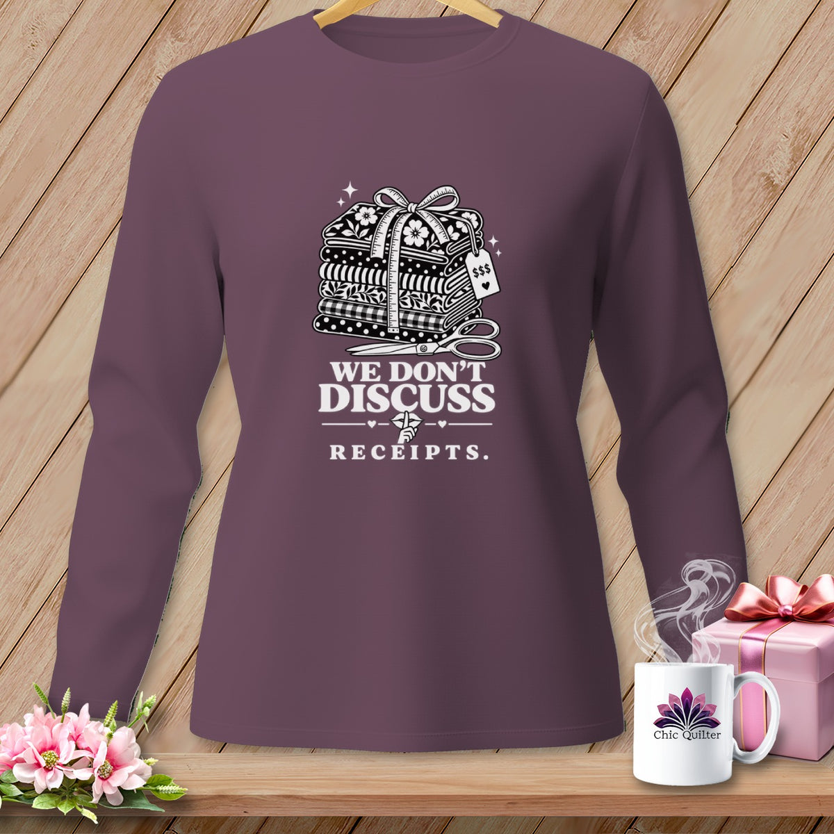 Purple long-sleeve shirt with "We Don't Discuss Receipts" and sewing motif.