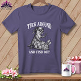 Purple t-shirt featuring an illustration of an otter sewing a rabbit into a quilt, with text reading TUCK AROUND AND FIND OUT.
