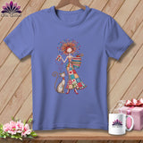 Lavender t-shirt featuring a whimsical illustration of a woman in a patchwork dress with a cat.