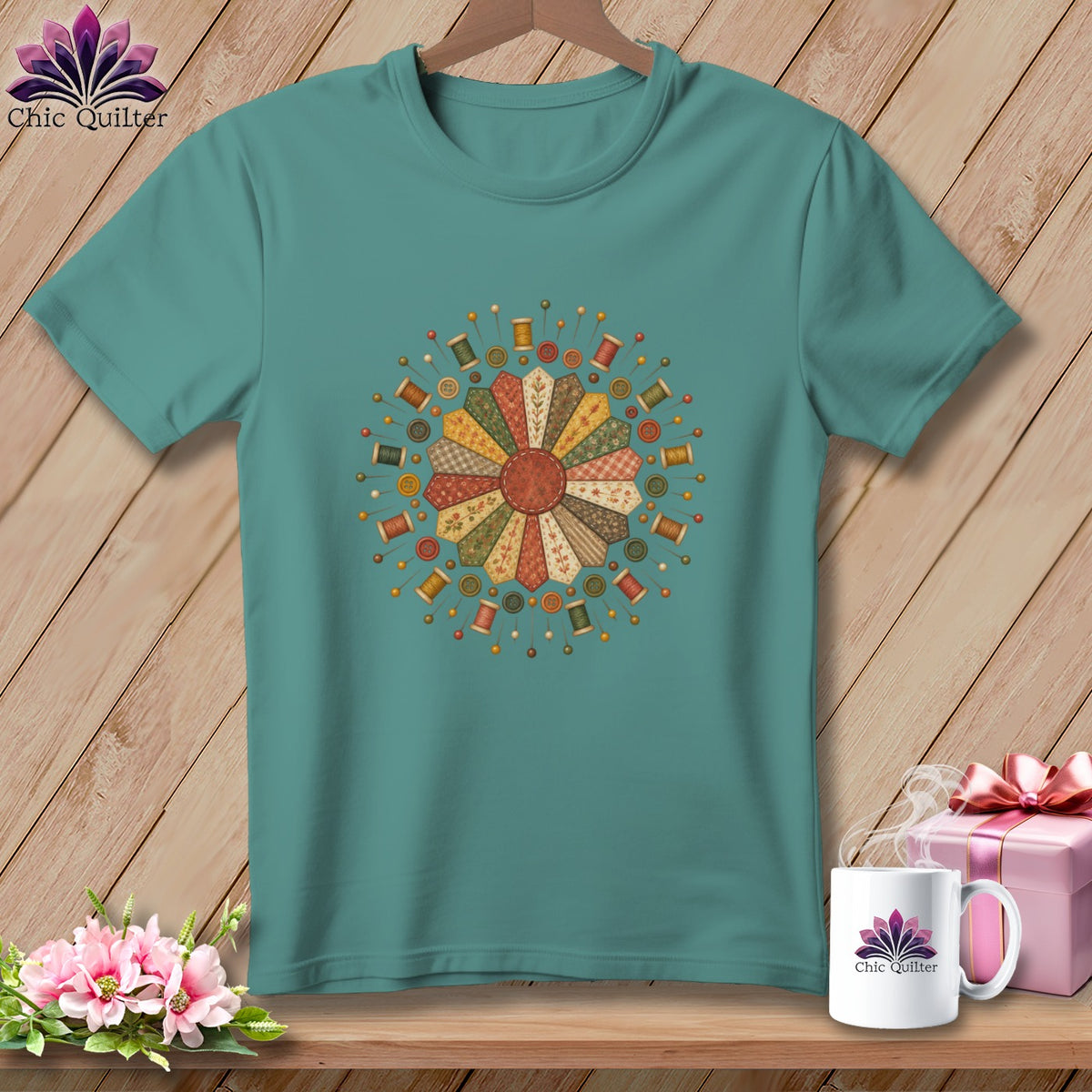 Teal t-shirt with a circular quilting design featuring spools, buttons, and pins.