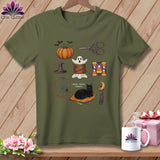 Olive green t-shirt with Halloween-themed sewing icons including a pumpkin, ghost, needle, thread, scissors, and cat.